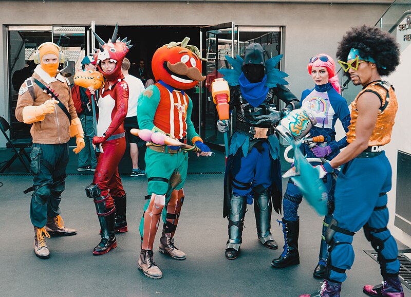 Group of fans wearing Fortnite video game cosplay costumes at an event convention